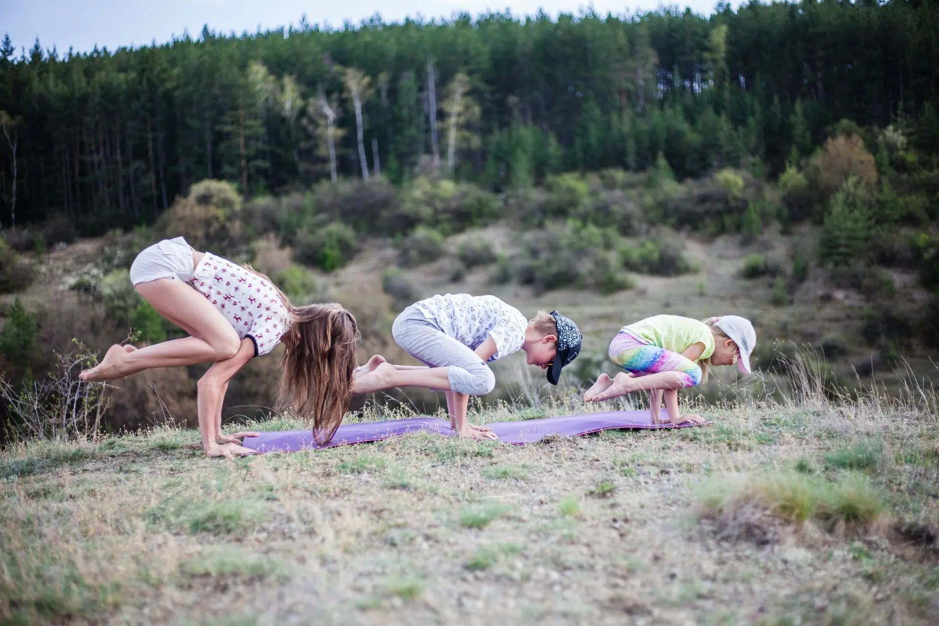 Eine Familie mehrerer Generationen macht gemeinsam Yoga in der Natur.
